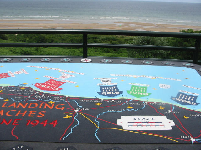 I forgrunden en tejning over landgangen og i baggrunden Omaha Beach